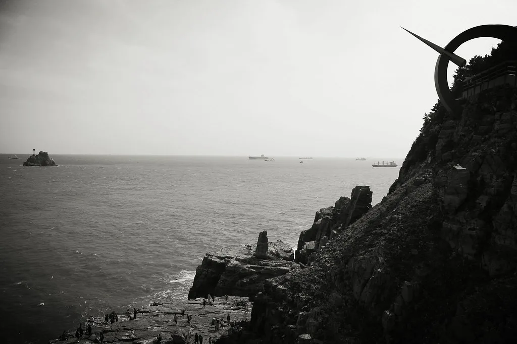 부산 태종대 해안 절벽과 흰 등대가 보이는 전경